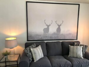 A couch with two deer in the background
