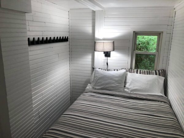 A bedroom with white walls and striped bedding.